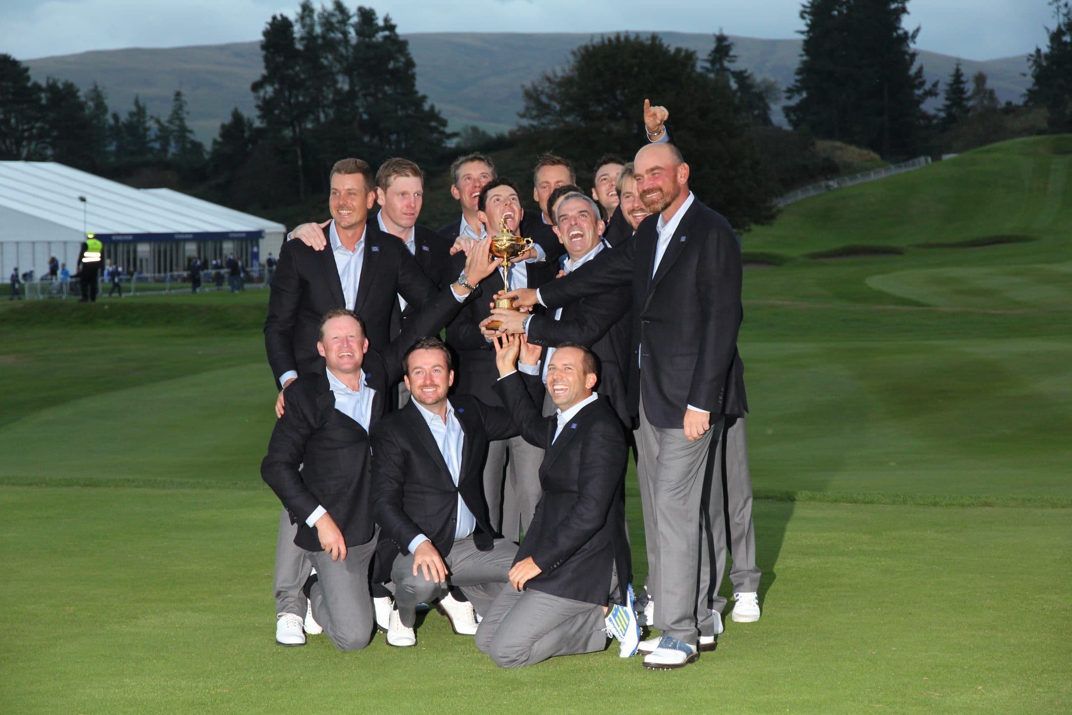 The European Ryder Cup team celebrating with the trophy on the 18th green
